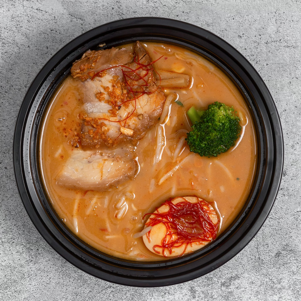 A bowl of Huntington Ramen & Sushi's ramen with pork, broccoli, and a marinated egg.
